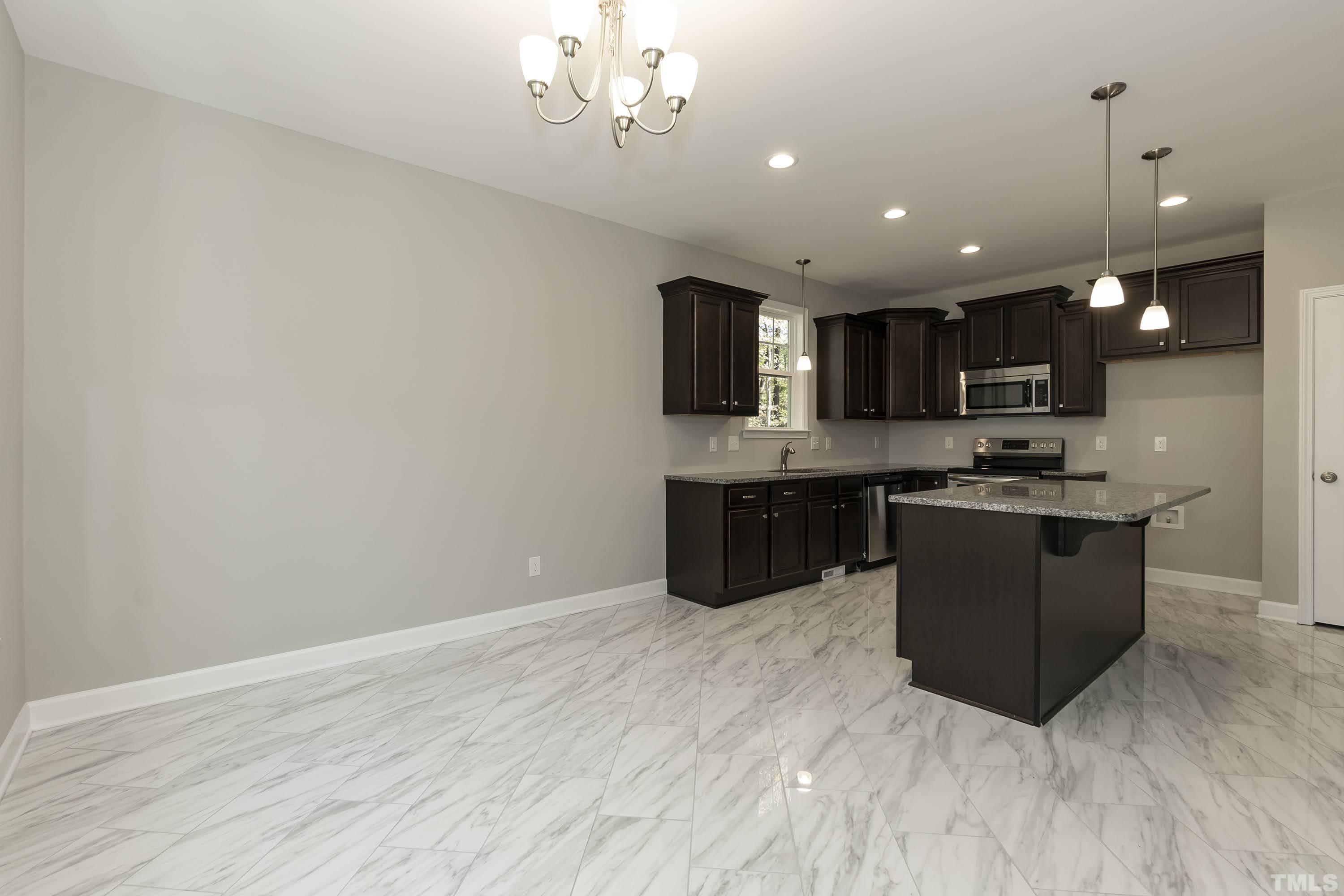 6002 East Pool Road Rougemont, NC 27572 - Photo 12 of 23 a large kitchen with stainless steel appliances granite countertop a large counter top and a stove
