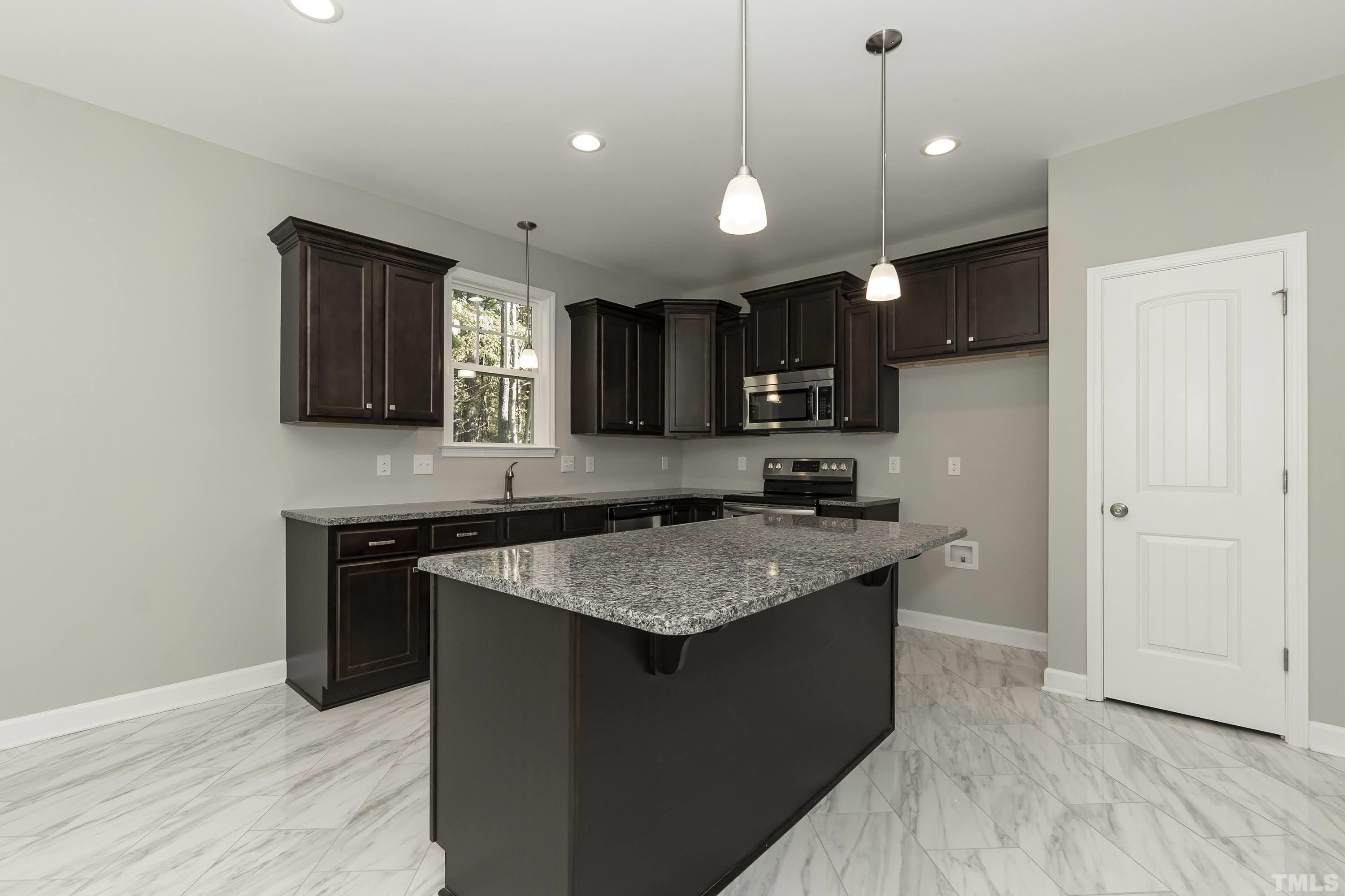 6002 East Pool Road Rougemont, NC 27572 - Photo 9 of 23 a kitchen with kitchen island granite countertop wooden cabinets and a sink