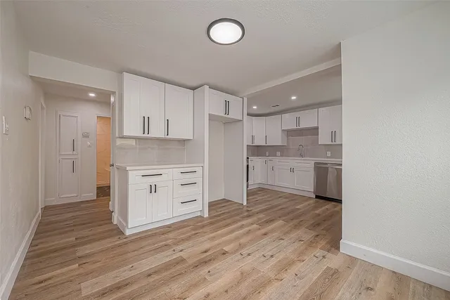 a view of a kitchen with dishwasher and wooden floor