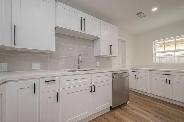 a kitchen with a sink cabinets and wooden floor