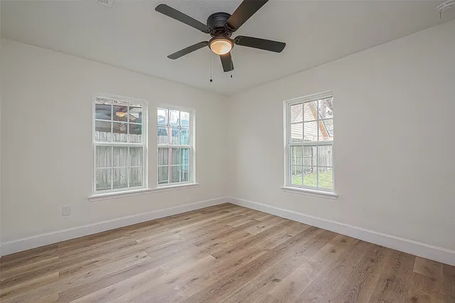 a view of empty room with wooden floor