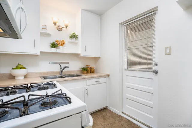 a kitchen with a sink a stove and cabinets