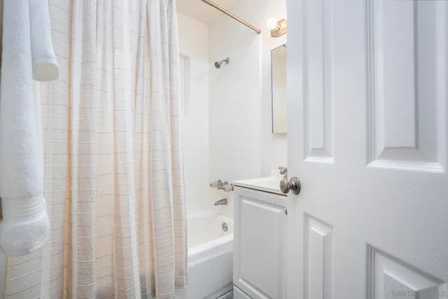 a bathroom with a sink a toilet and shower curtain
