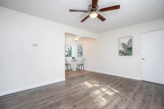 a view of a livingroom with a hardwood floor and a ceiling fan