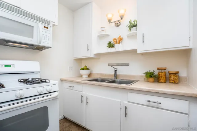 a kitchen with white cabinets and a stove