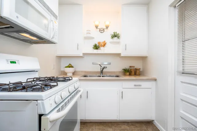 a kitchen with granite countertop a sink stove and cabinets
