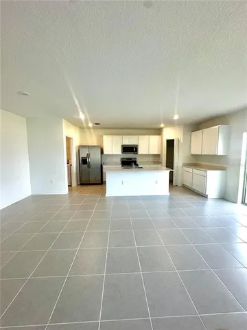 a large kitchen with kitchen island granite countertop a sink and a stove