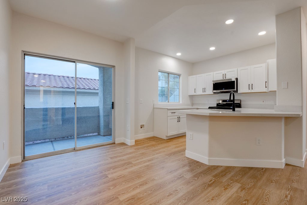 1881 West Alexander Road, Unit 1129 North Las Vegas, NV 89032 - Photo 17 of 31 Kitchen featuring white cabinets, light wood-type flooring, recessed lighting, stainless steel microwave, and gas stove