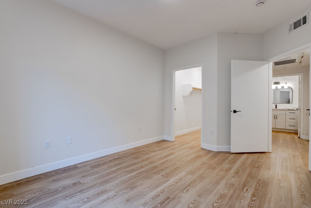 1881 West Alexander Road, Unit 1129 North Las Vegas, NV 89032 - Photo 22 of 31 Unfurnished bedroom featuring a walk in closet and light wood-style flooring