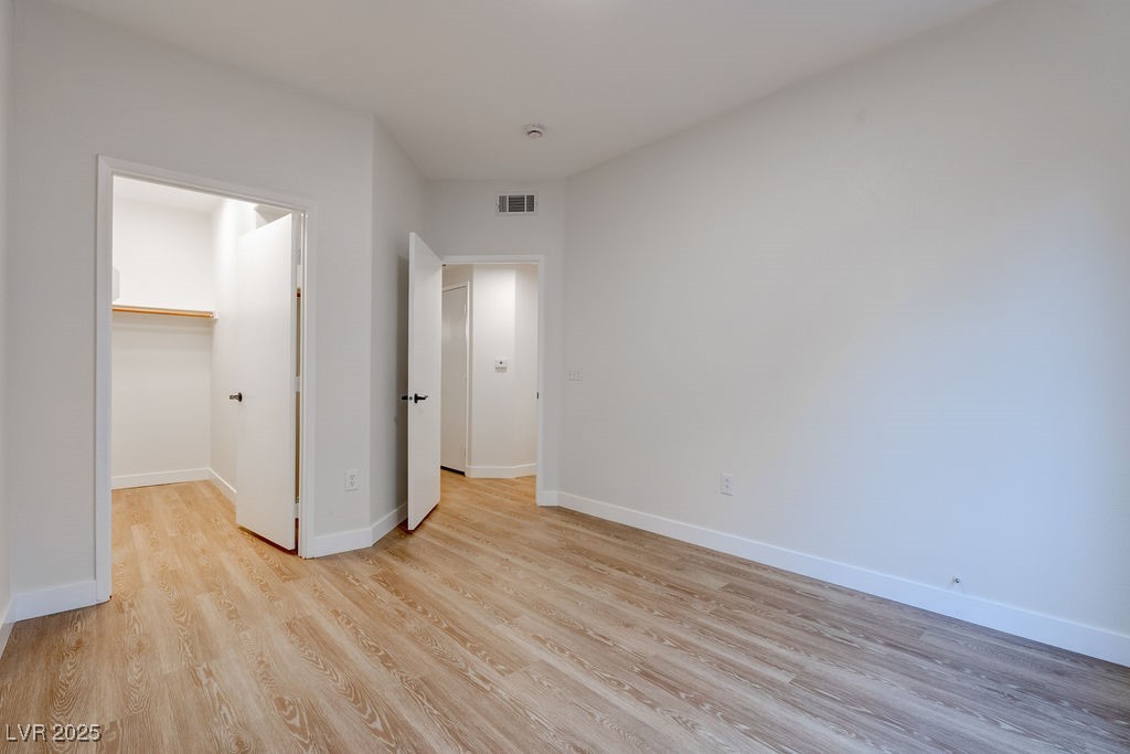 1881 West Alexander Road, Unit 1129 North Las Vegas, NV 89032 - Photo 23 of 31 Unfurnished bedroom with light wood finished floors and a spacious closet