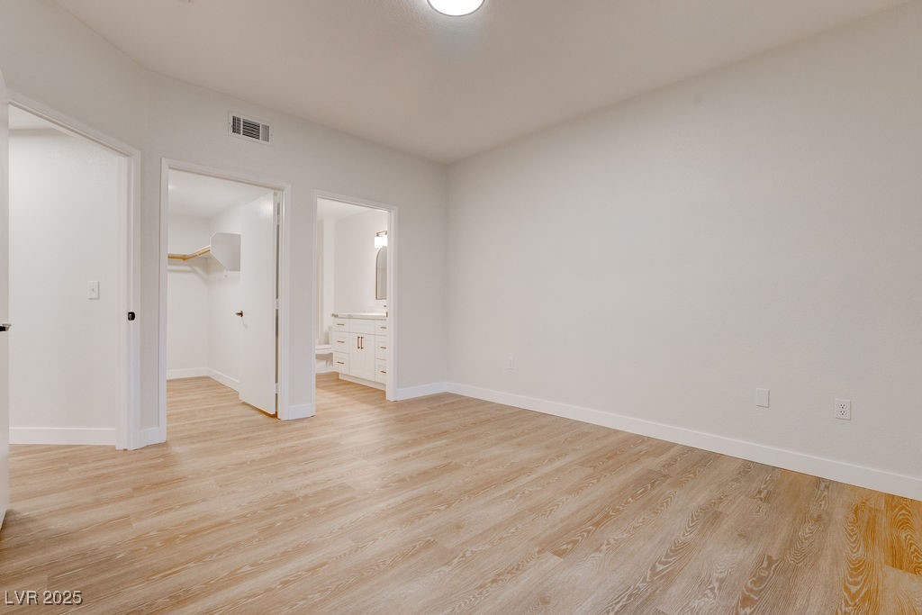 1881 West Alexander Road, Unit 1129 North Las Vegas, NV 89032 - Photo 6 of 31 Primary bedroom with a spacious closet, light wood-style floors, and connected bathroom