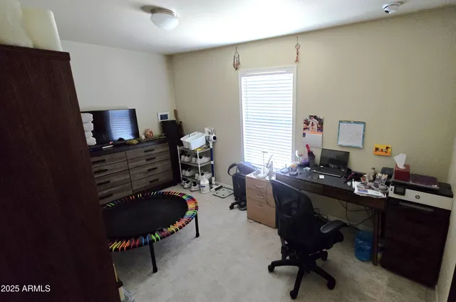 a view of a workspace with furniture and a window