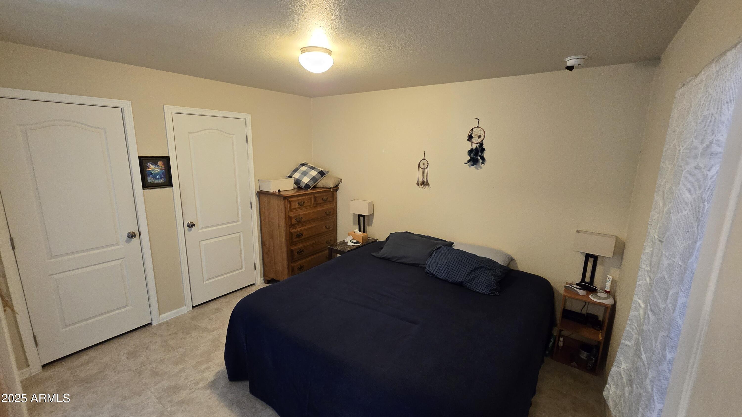 10540 East Apache Trail, Unit 182 Apache Junction, AZ 85120 - Photo 21 of 30 a bedroom with a bed and cabinets