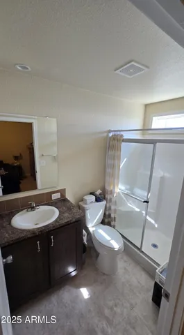 a bathroom with a granite countertop sink toilet and shower