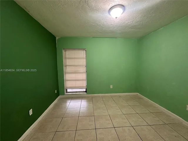 a view of a backyard with brick wall and a large tree
