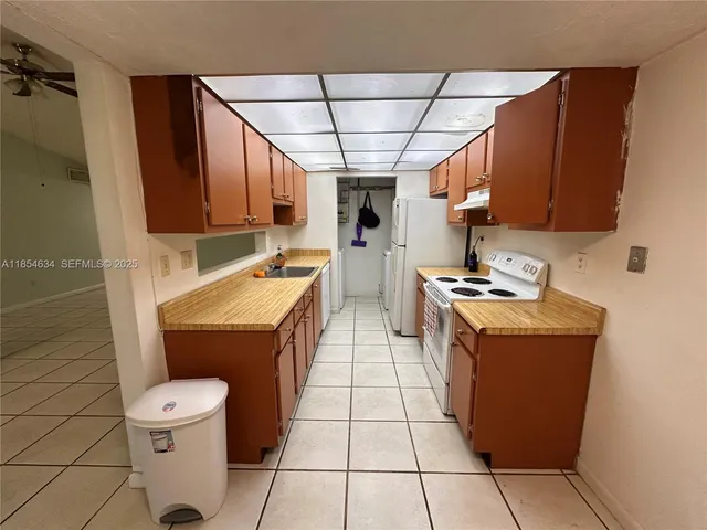 a kitchen with a sink a stove top oven and cabinetry