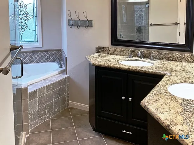 a bathroom with a granite countertop sink a mirror and