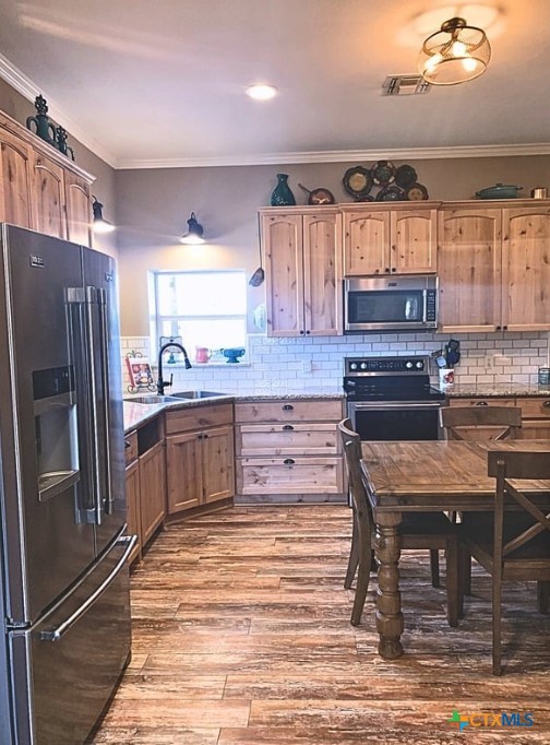 949 Abrameit Road Goliad, TX 77963 - Photo 26 of 30 a kitchen with stainless steel appliances wooden floor and a refrigerator