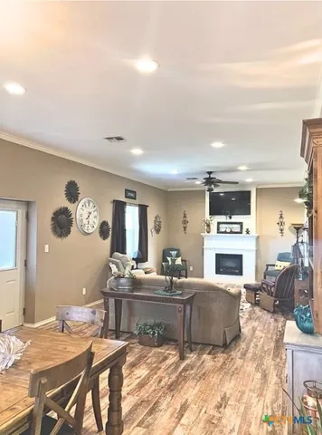 a living room with furniture kitchen view and a fireplace