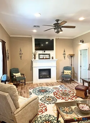 a living room with furniture a flat screen tv and a fireplace