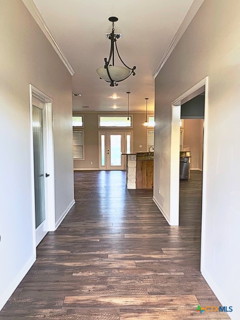 949 Abrameit Road Goliad, TX 77963 - Photo 7 of 30 a view of a hallway with wooden floor and a kitchen