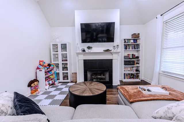 a living room with furniture a flat screen tv and a fireplace
