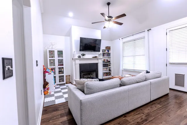 a kitchen with stainless steel appliances kitchen island granite countertop a stove a refrigerator a sink a dining table and chairs with wooden floor