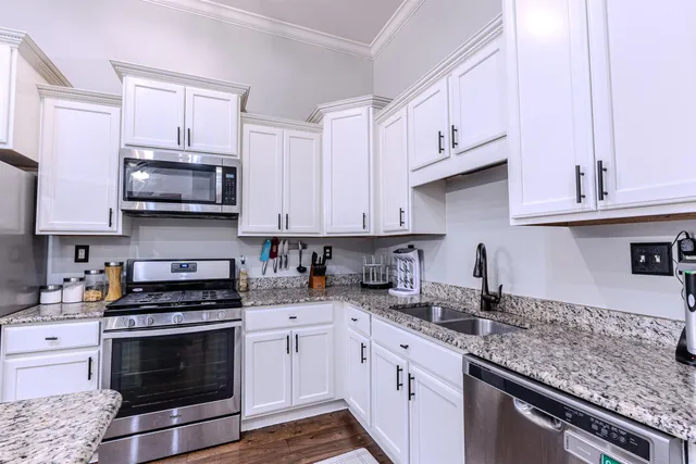 a kitchen with stainless steel appliances granite countertop a sink stove and refrigerator