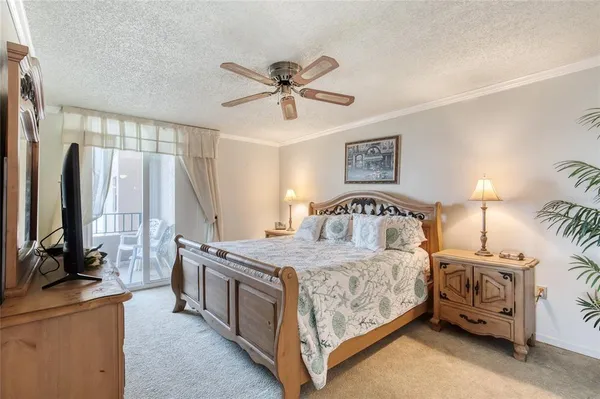 a bedroom with a bed and a flat tv screen on dresser