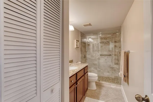 a bathroom with a granite countertop sink toilet a mirror and shower
