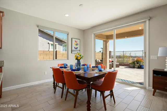 a kitchen with stainless steel appliances granite countertop a stove a sink a refrigerator a dining table and chairs