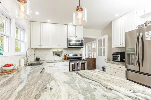 a kitchen with stainless steel appliances a stove sink microwave and refrigerator