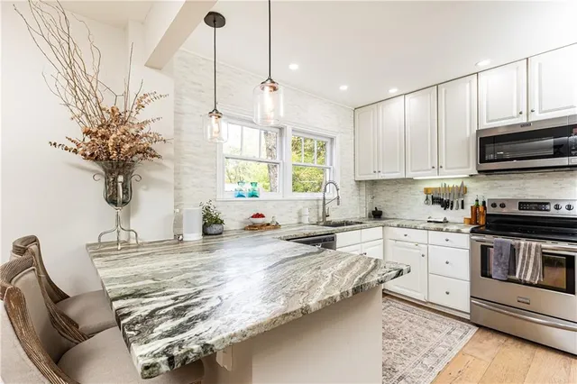 a kitchen with granite countertop a stove a sink and a refrigerator