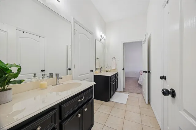a spacious bathroom with a double vanity sink a mirror and shower