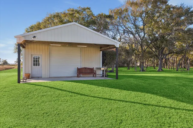 a view of a house with backyard and trees