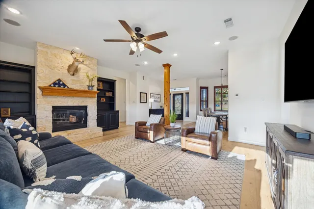 a living room with furniture a flat screen tv and a fireplace