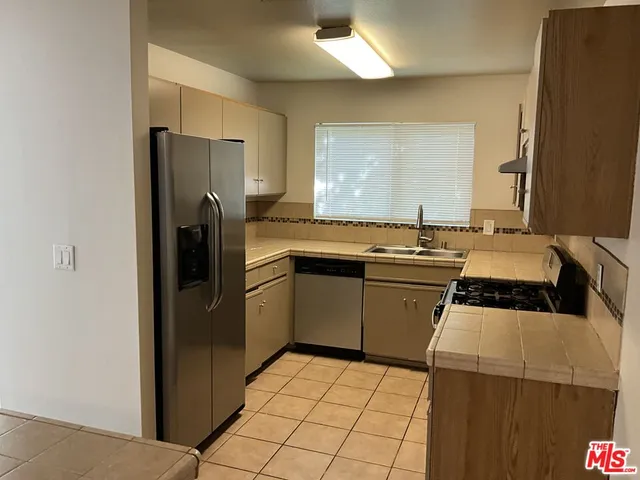 a kitchen with a stove a refrigerator and a sink
