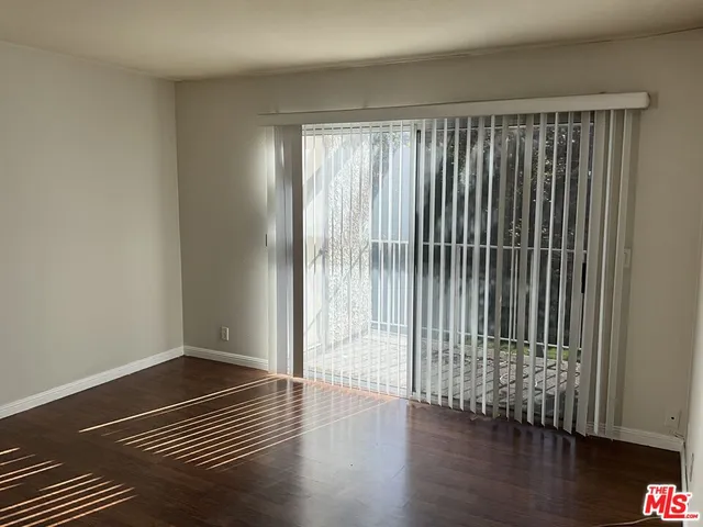 a view of wooden floor and a window in a room