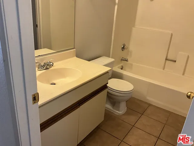 a bathroom with a granite countertop toilet and a sink