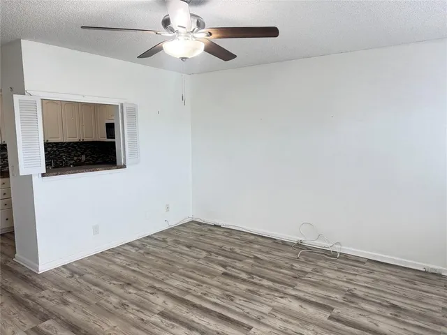 en empty room with wooden floor and ceiling fan