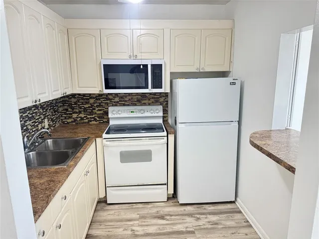 a kitchen with white cabinets and white appliances
