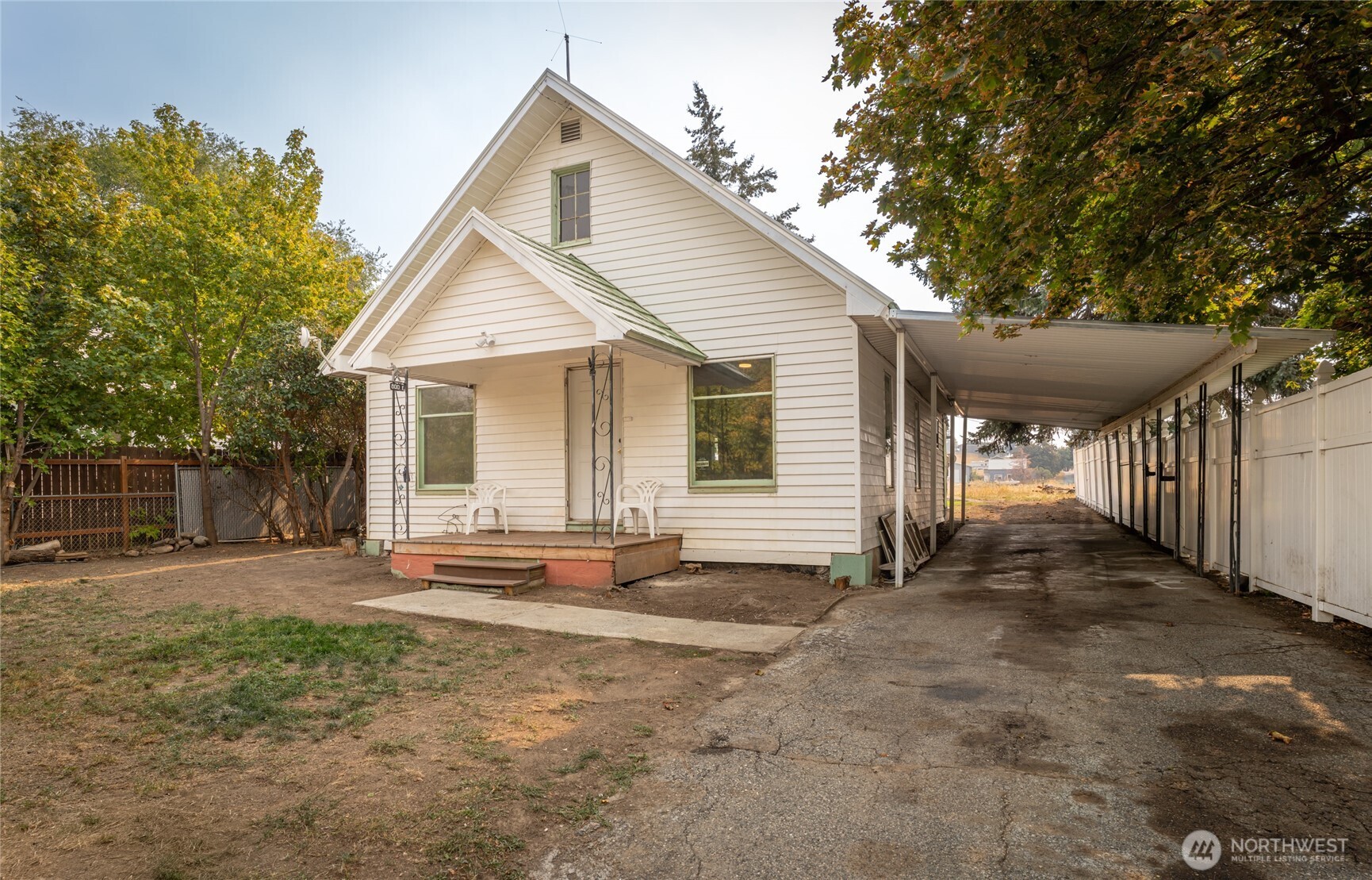 a view of a house with a yard and large tree