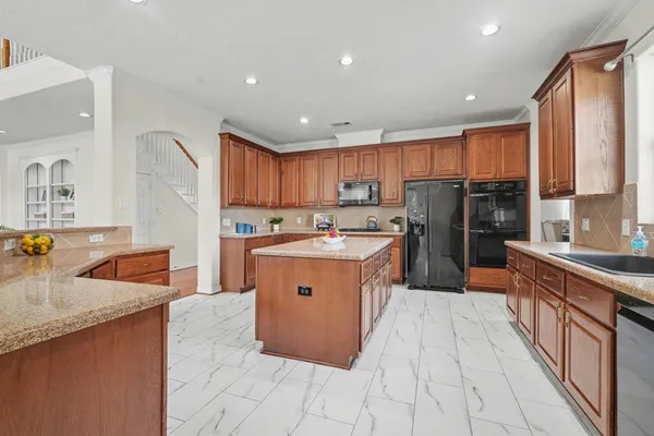 a large kitchen with stainless steel appliances granite countertop a stove a sink dishwasher a refrigerator and a oven