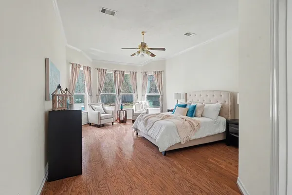 a bedroom with a bed couch and a large window