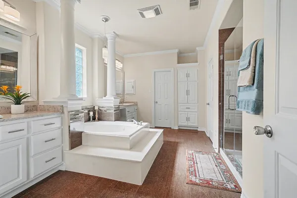 a spacious bathroom with a double vanity sink a mirror a shower and a bathtub