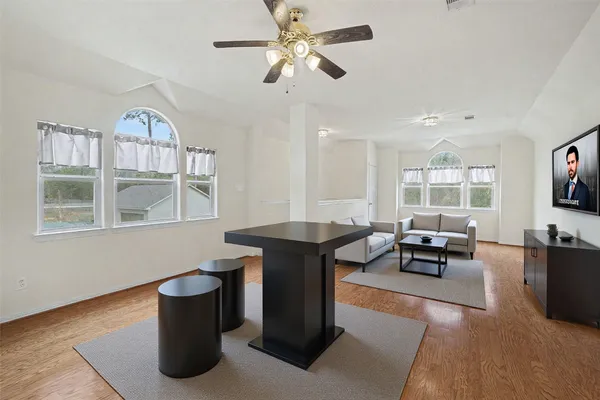a living room with furniture a flat screen tv and windows