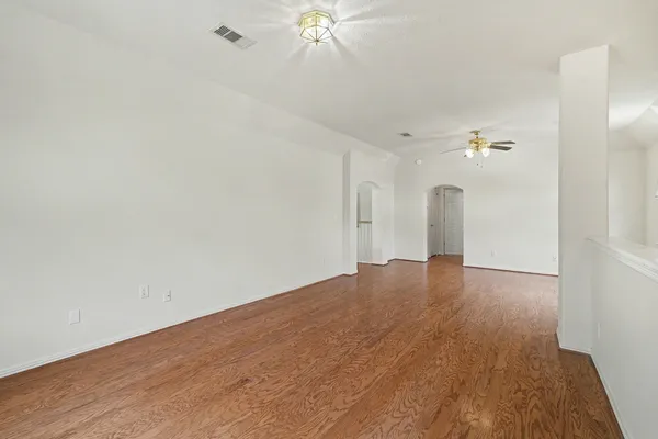 a view of a livingroom with wooden floor and a ceiling fan