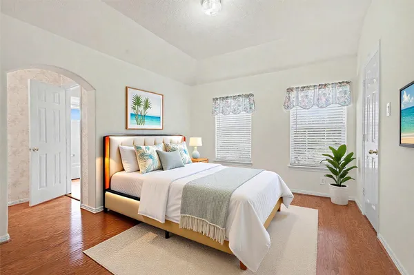 a bedroom with a large bed and a potted plant