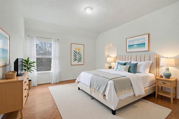 a bedroom with a bed and a potted plant