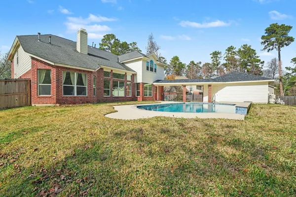 a front view of house with yard and trees in the background